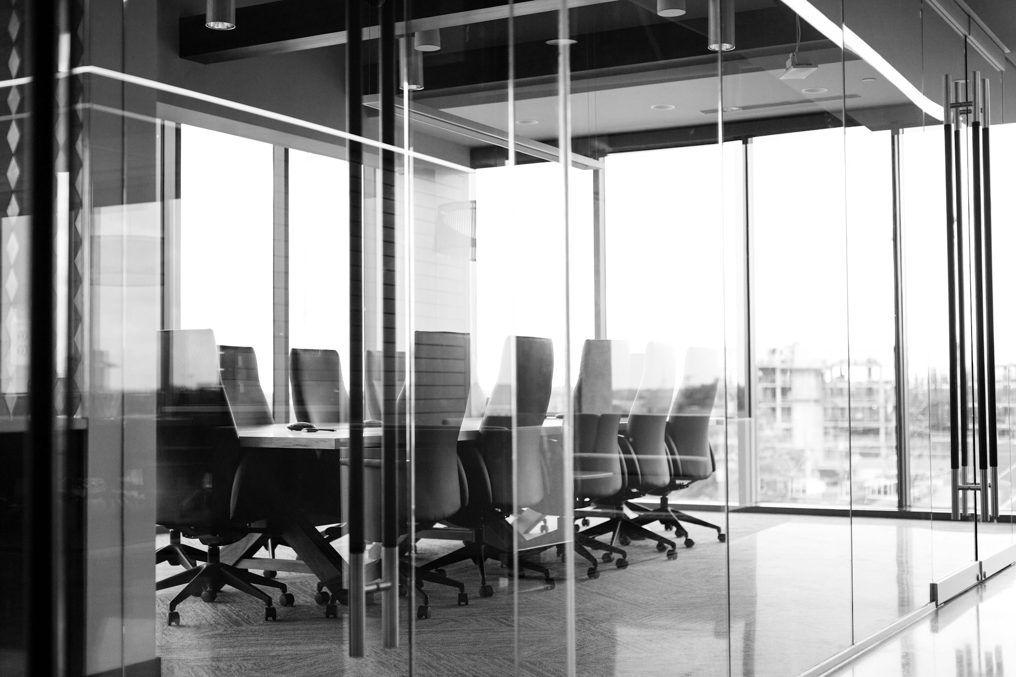 Picture of an empty conference room with glass walls on the top floor of a modern office building. 