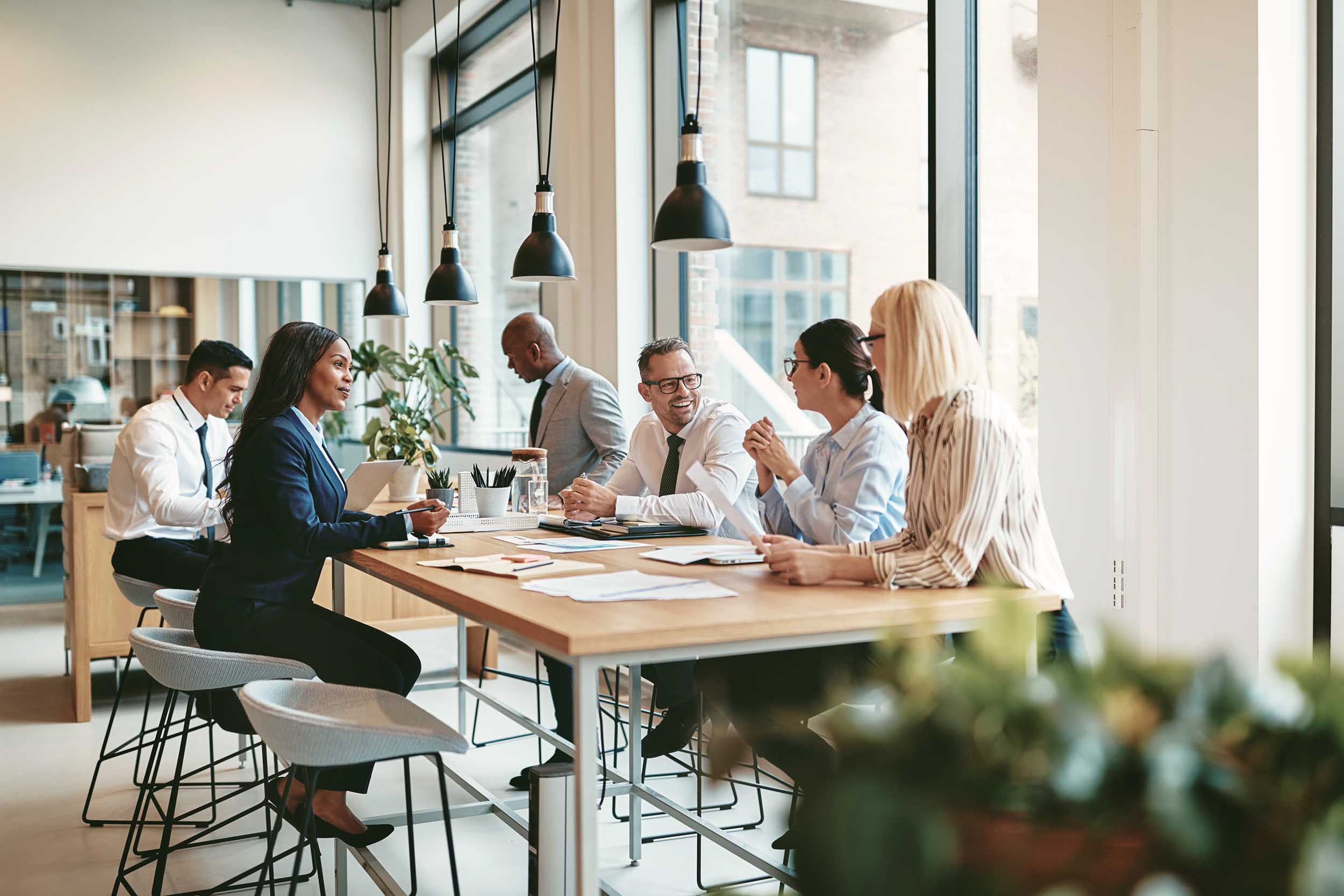 colleagues working on tall tables in a hybrid office